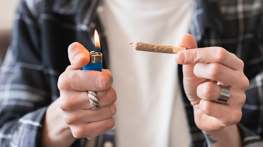 Man lighting a joint mixed with live resin and value buds from chronic farms online weed dispensary for dispensary weed.