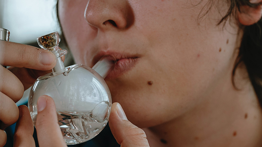 Woman smoking live resin from a small bong. Buy weed online in Canada from online dispensary Chronic Farms mail order marijuana weed store. dispensary weed.